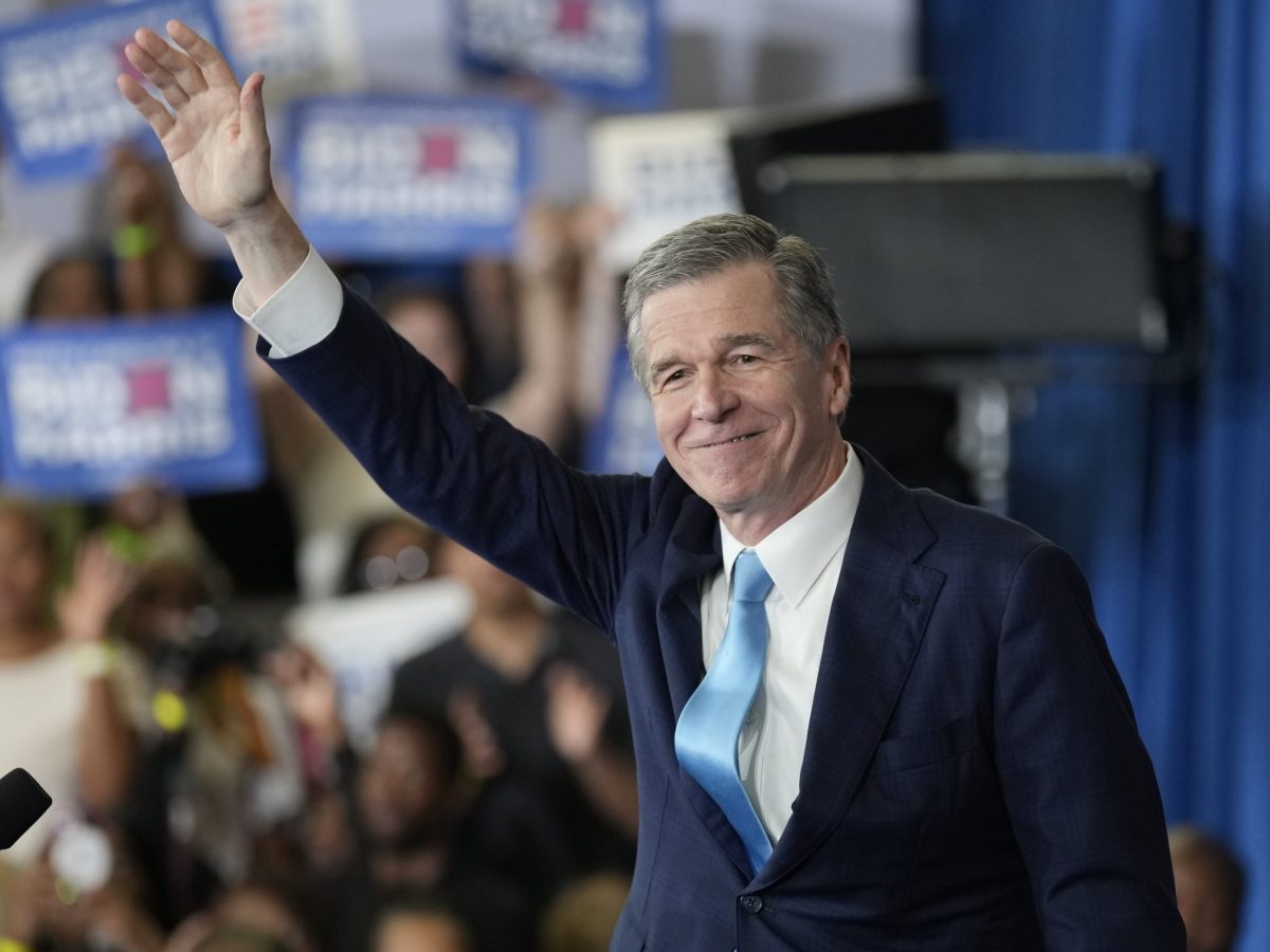 Roy cooper waves to the crowd at a Biden event