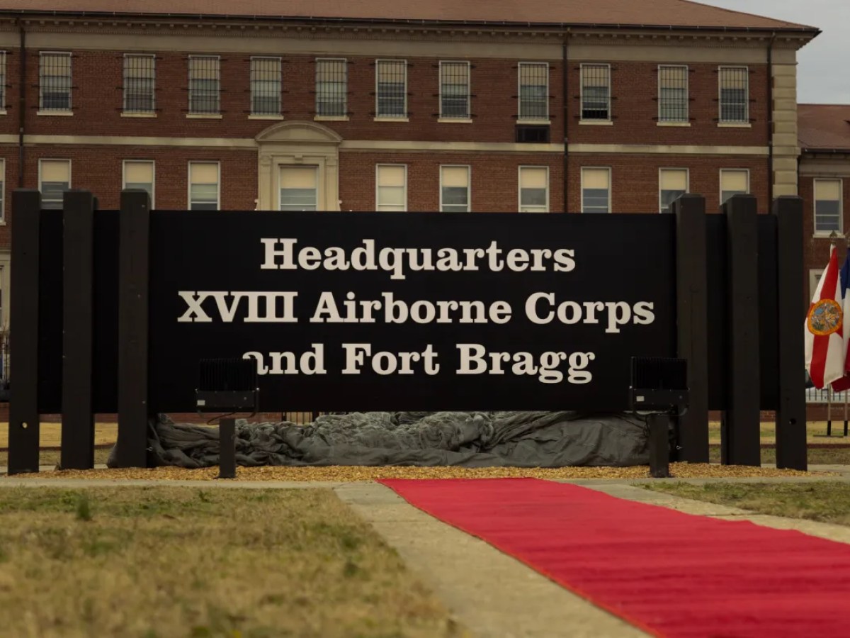 A large sign in front of a brick building reads "Headquarters XVIII Airborne Corps and Fort Bragg"