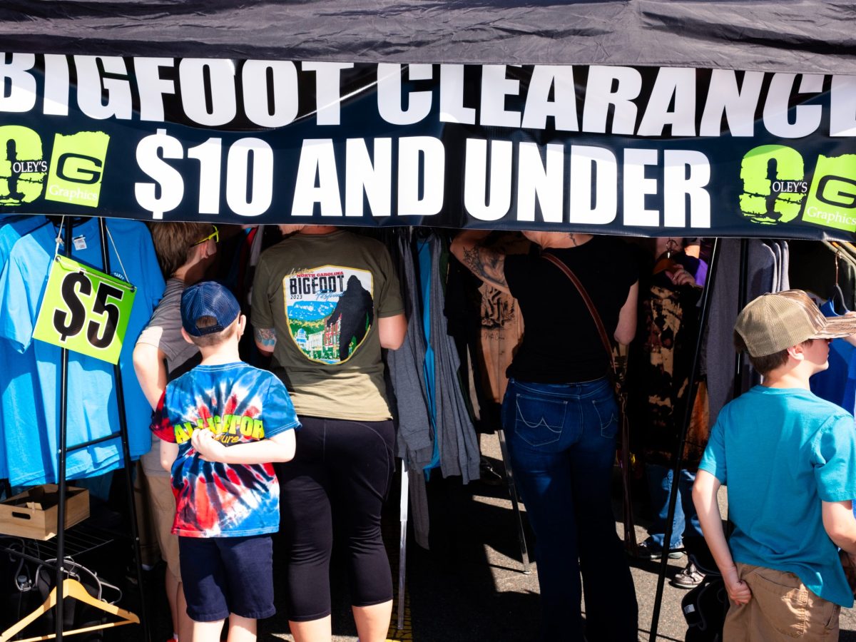 shoppers under a tent selling bigfoot merchandise