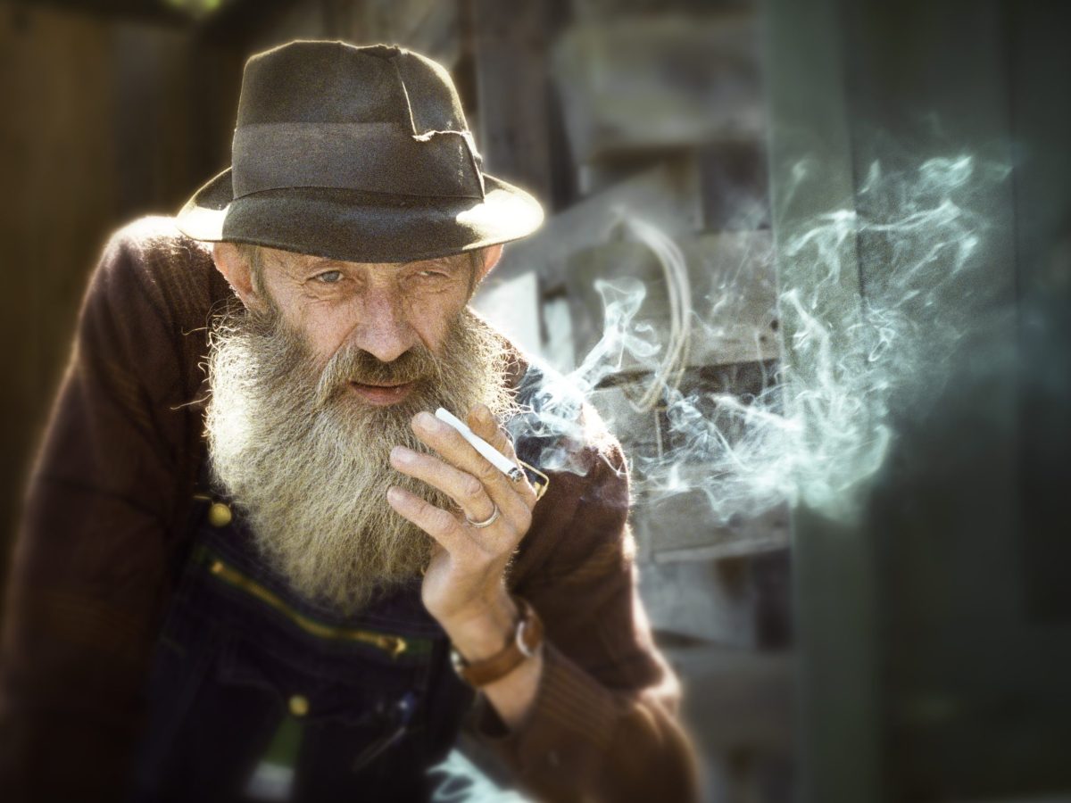 A man in a hat smokes